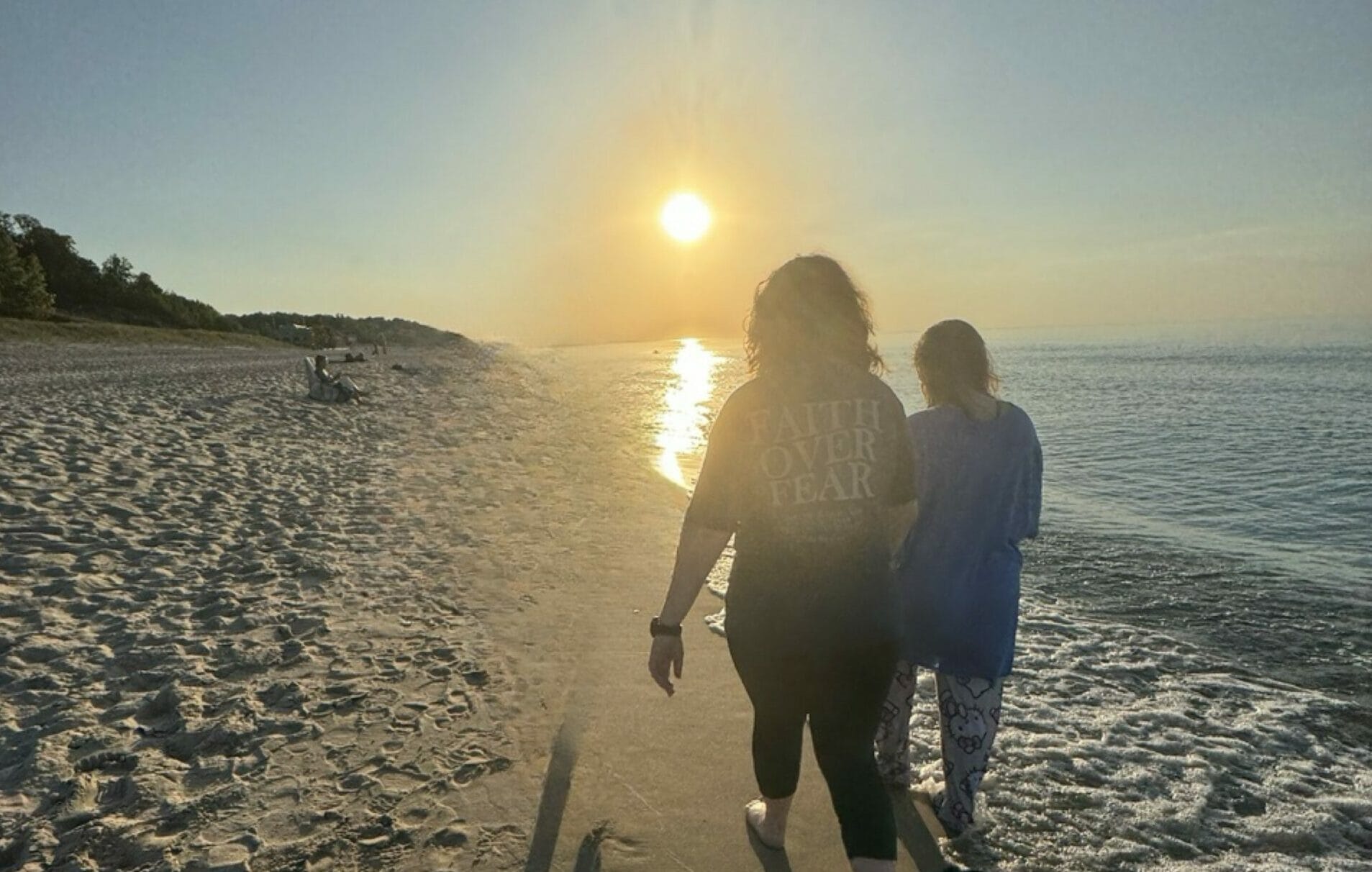 girls walking beach at sunset